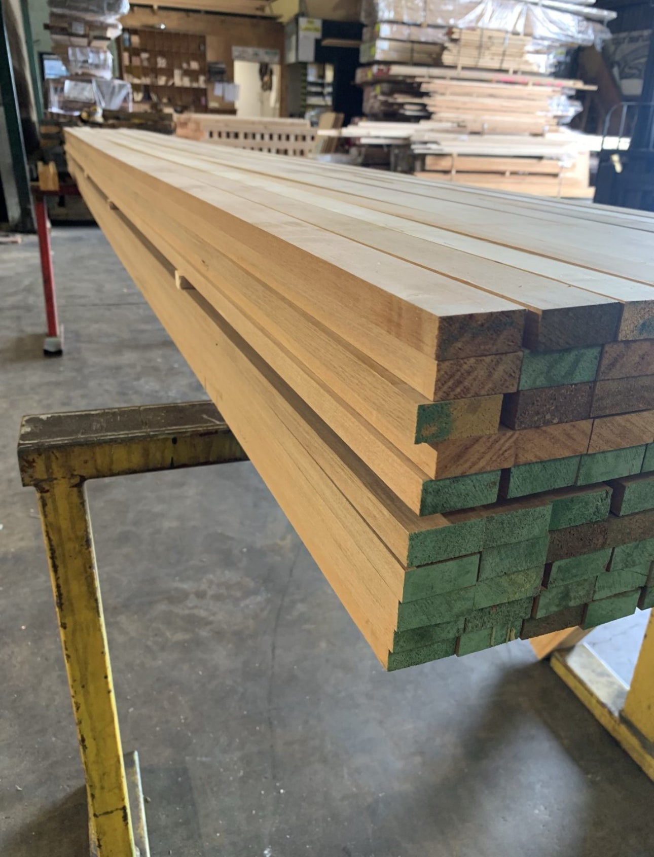 Stack of wooden planks on a metal stand in a warehouse setting